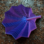 An intricate, multi-pointed star stress toy with a blue and purple vortex design sitting on a textured wooden surface.