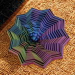 An intricate, multi-pointed star stress toy with a blue and purple vortex design sitting on a textured wooden surface.