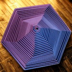 3D layered hexagonal geometric sculpture in green and teal gradient, top-down view on a textured brown background, focus tool for meditation.