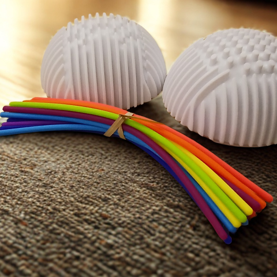 Top-down view of colorful silicone stretch strings coiled inside a light-grey textured tactile sensory sphere.
